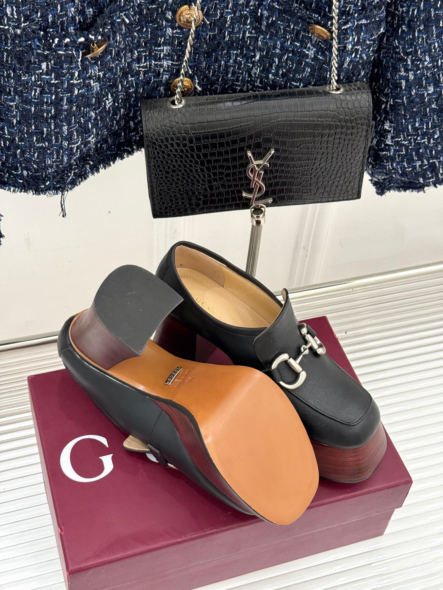 Black leather platform loafers with chunky heels and silver chain-link hardware