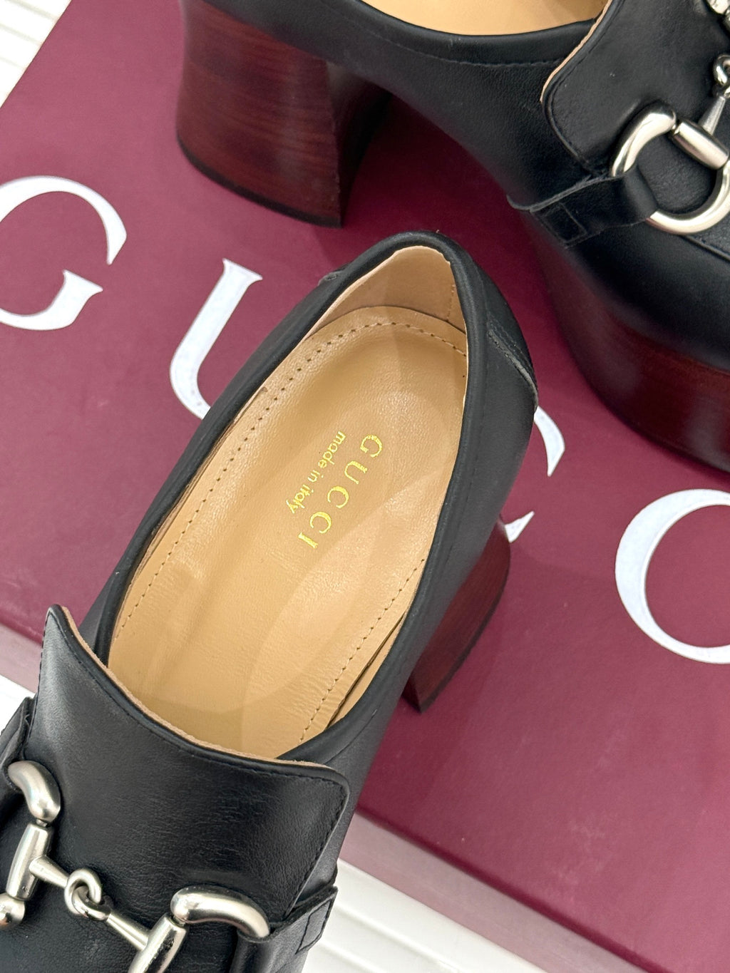 Black leather loafer with silver chain hardware and tan interior lining