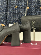 Black Gucci loafer platform heels, close-up of block heels and gold-tone hardware