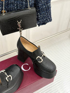 Black Gucci loafer platform heel with gold-tone bit hardware, side view
