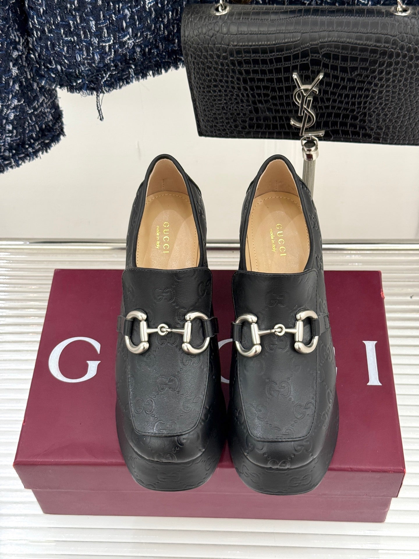 Black Gucci loafer platform heels pair on a box, with gold-tone bit hardware