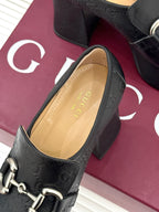 Black Gucci loafer platform heel with gold-tone bit hardware and tan insole