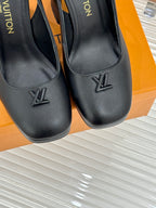 Close-up of ladies black platform heels with LV logo and chunky block heel