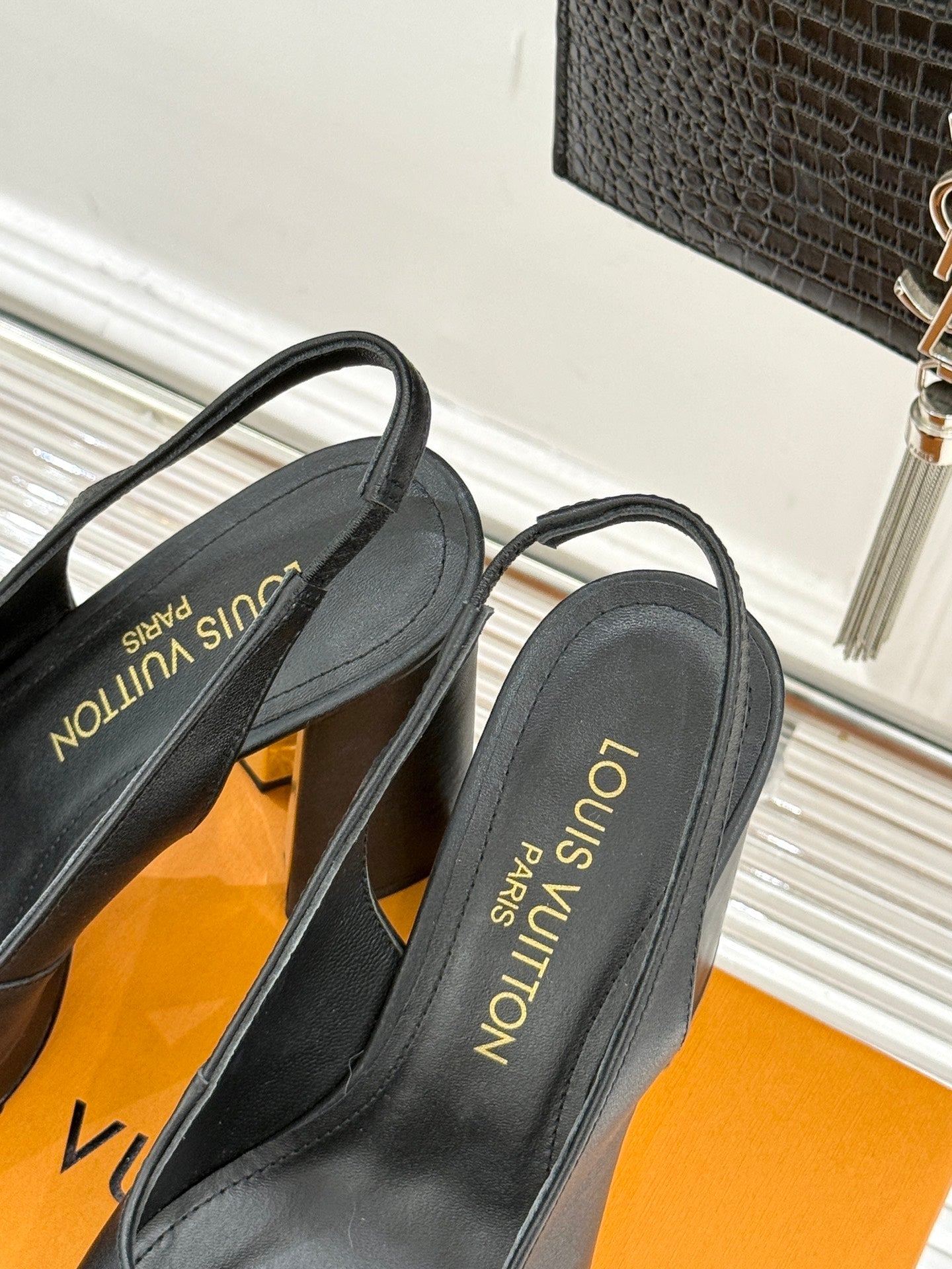 Back view of ladies black platform heels with LV text on inner lining