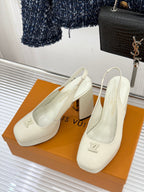 Pair of white Louis Vuitton leather pumps with block heels, side angle view