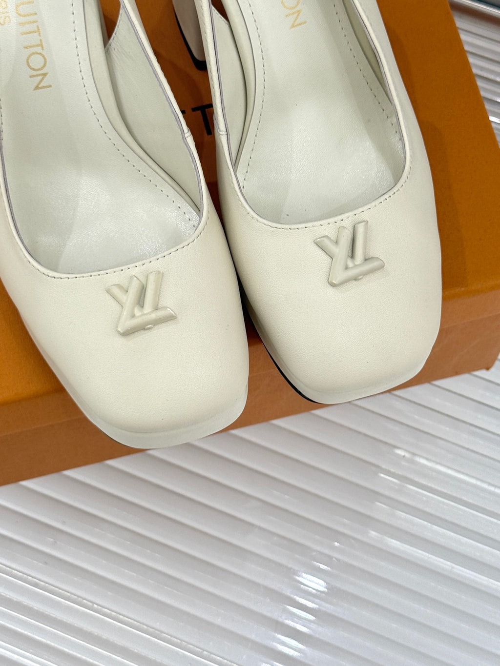 Close-up of white Louis Vuitton leather pumps with V emblem on toe
