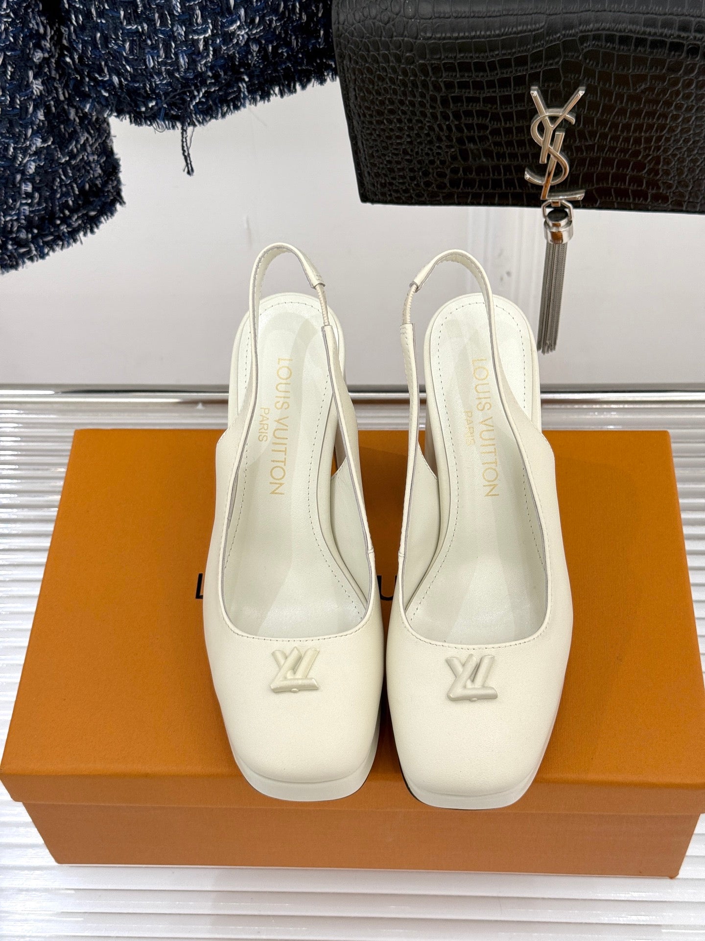 White Louis Vuitton leather pumps, back view, rounded toe with V emblem