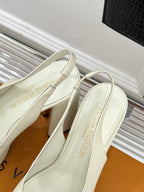 White Louis Vuitton leather pumps close-up of topline and V logo