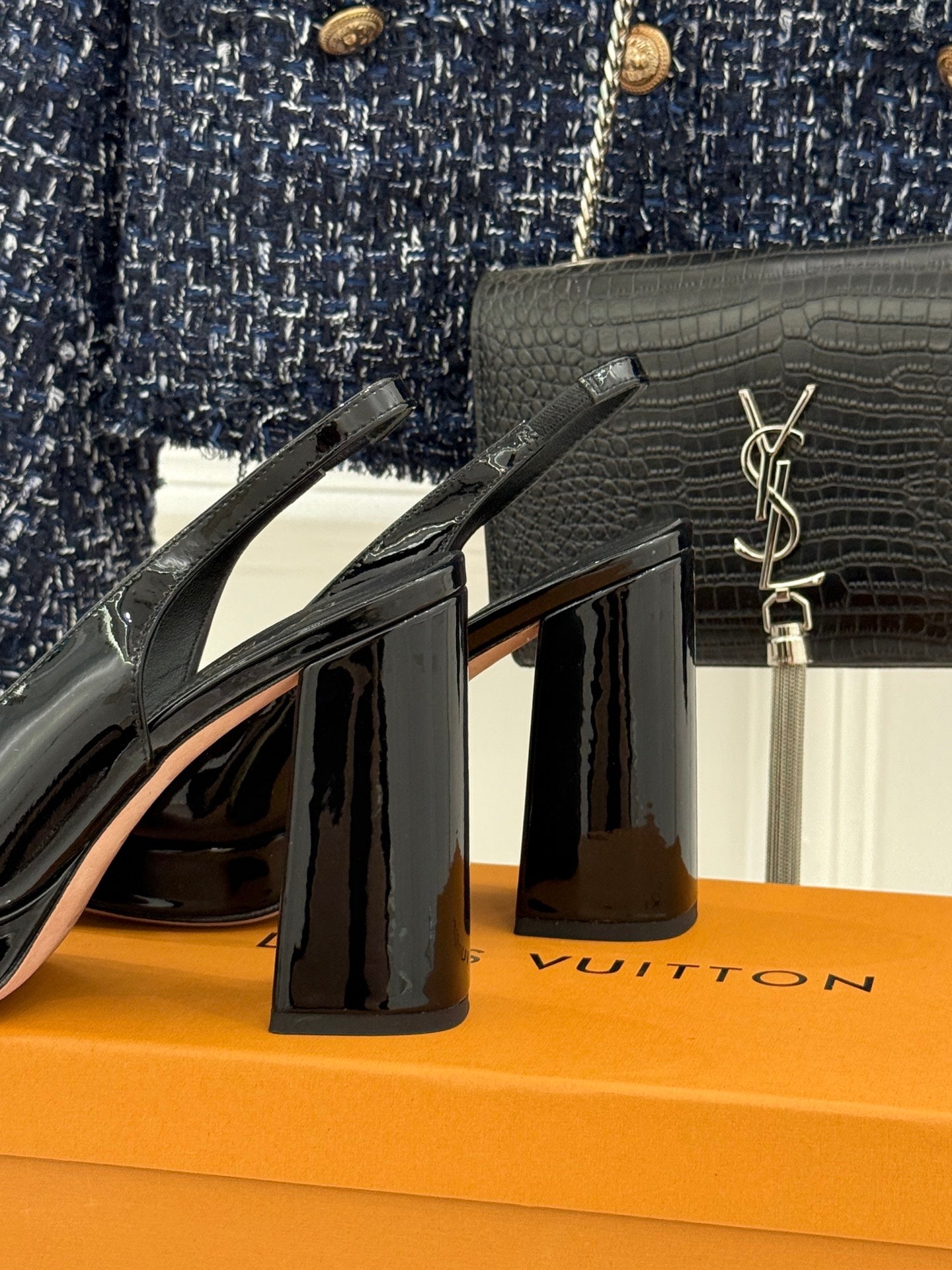 Black glossy high-heel pumps with LV logo emblem on vamp