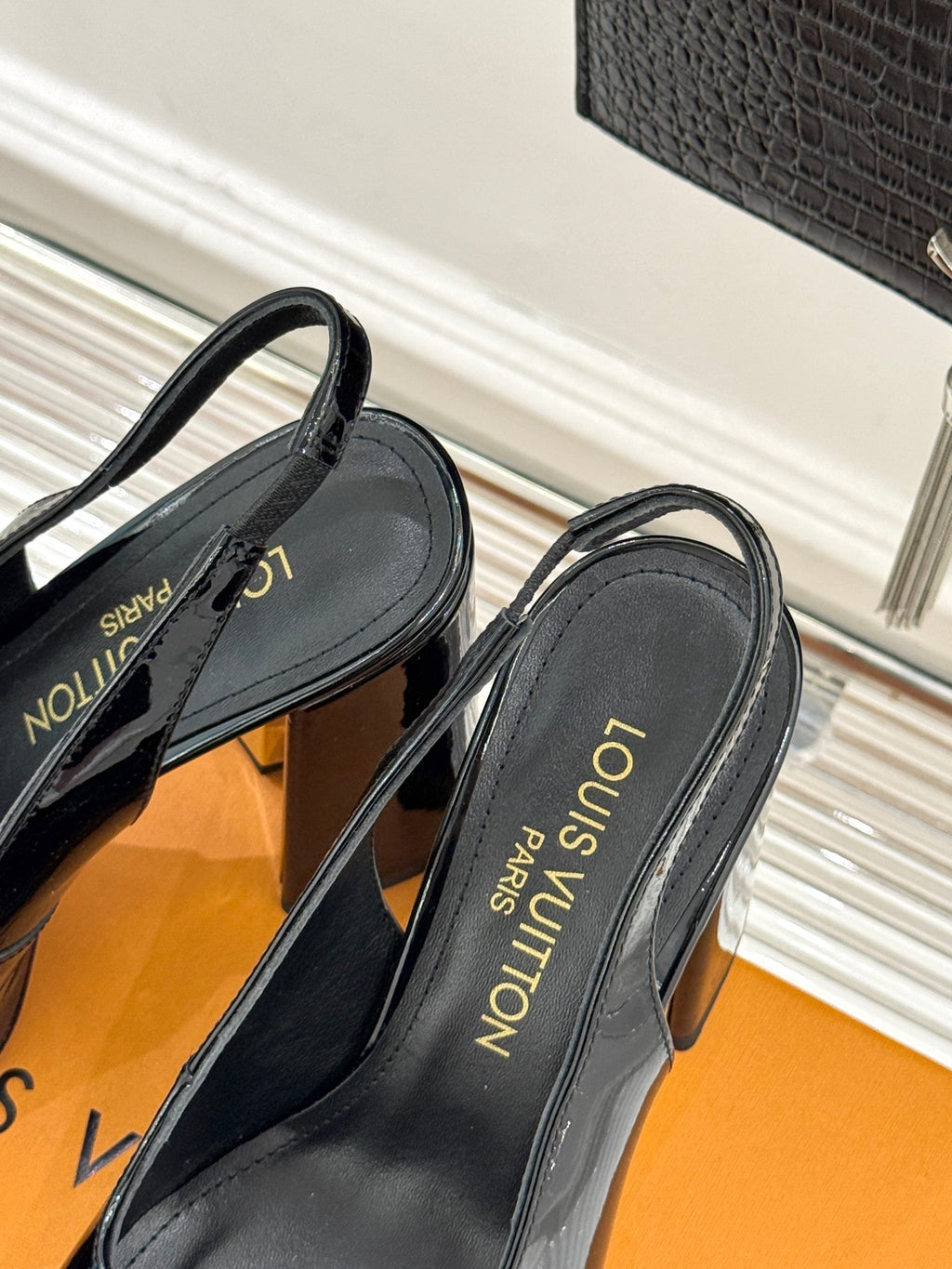 Black leather pumps with LV printed text on insole, open back