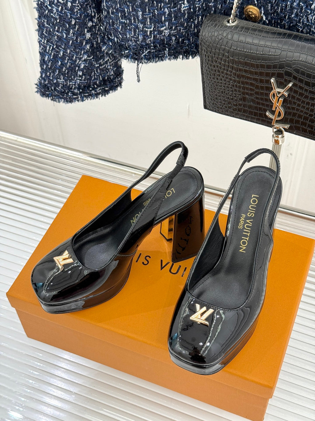 Black patent leather high-heel slingback pumps with LV logo detail