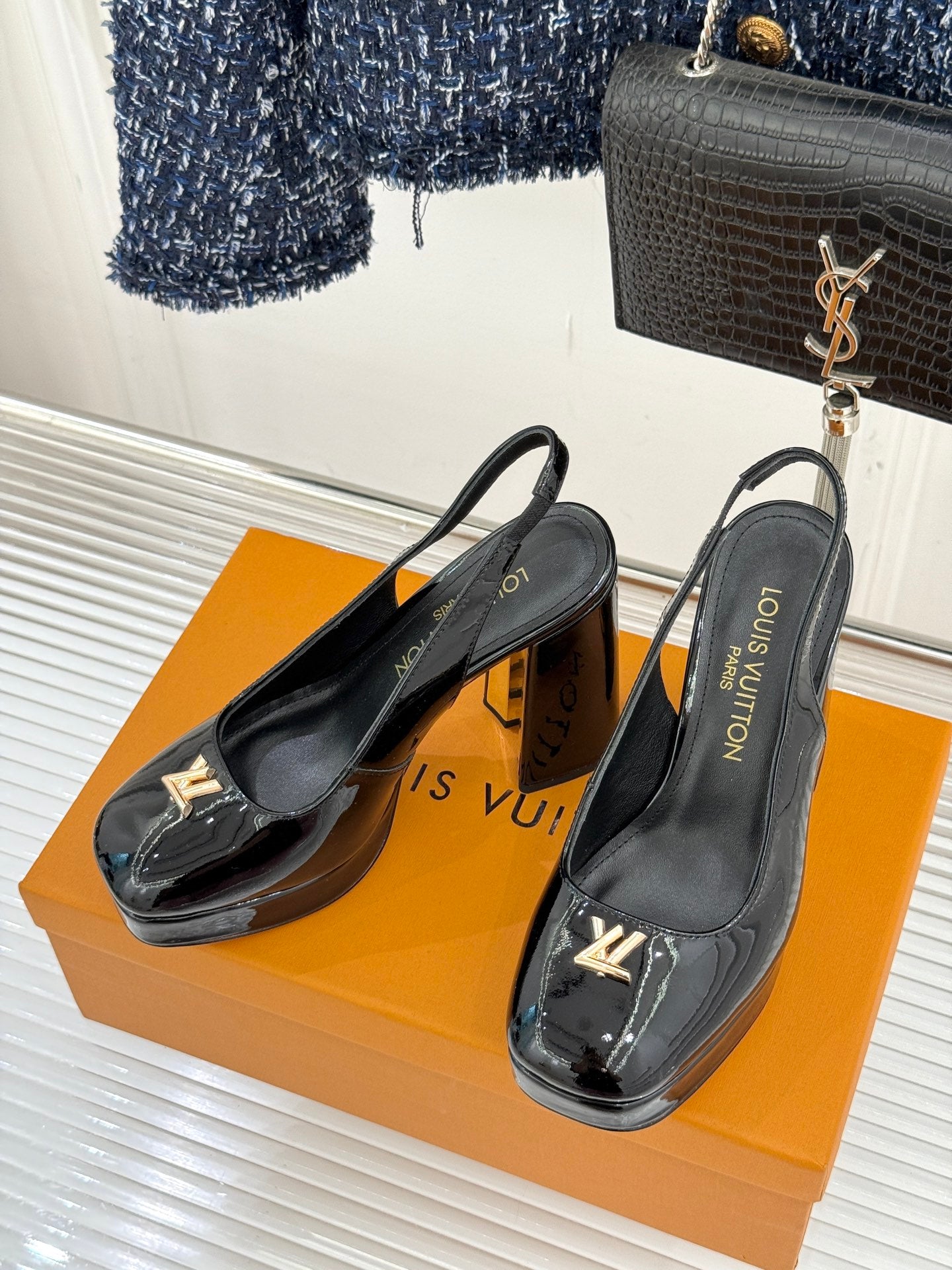 Black patent leather high-heel slingback pumps with LV logo detail
