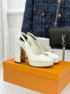 White patent high-heel shoes with gold LV logo detail on strap