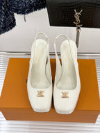 Pair of white patent leather high-heel shoes with gold LV logo on fronts