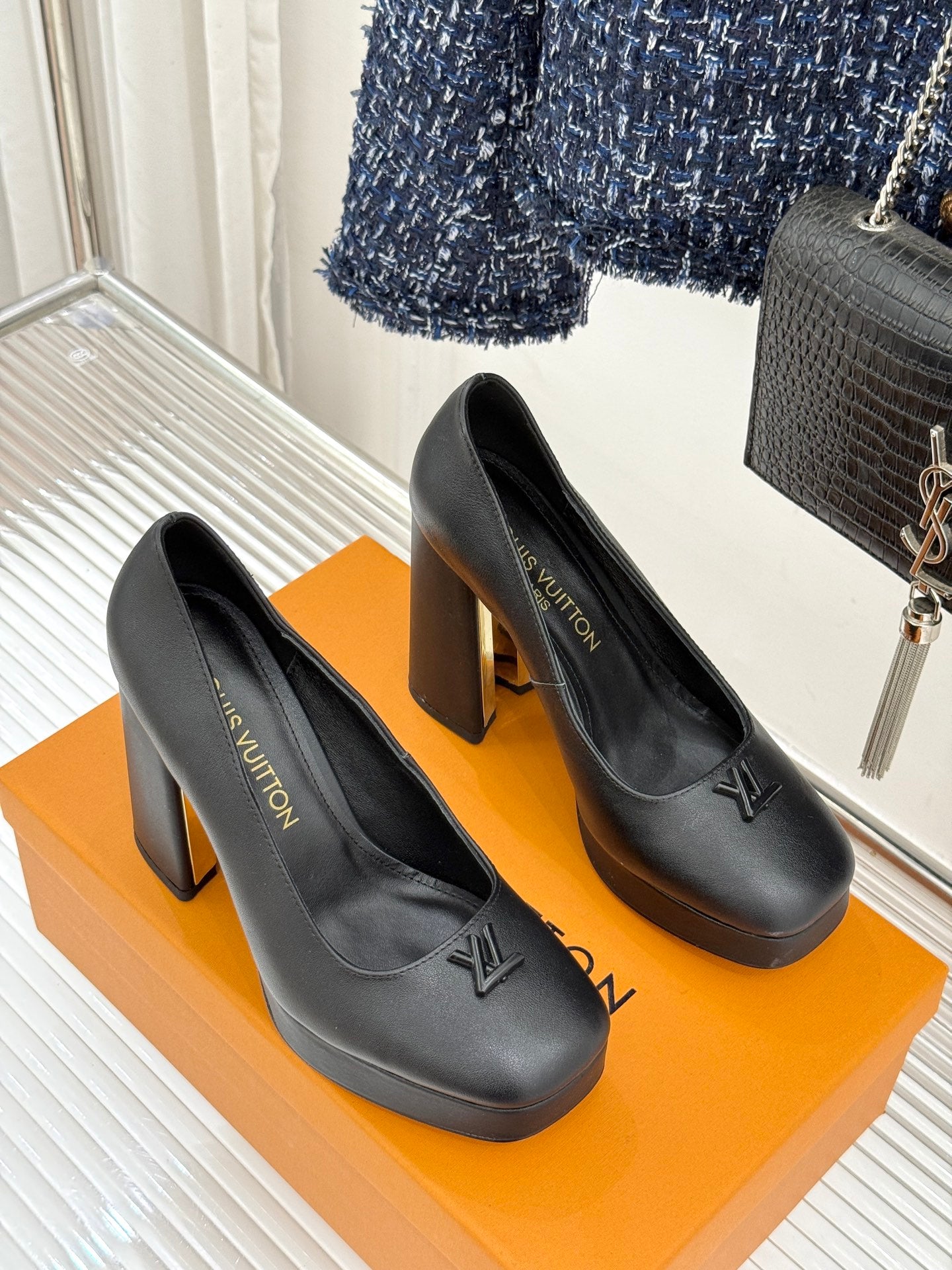 Black leather platform pumps with LV monogram and tall block heel on display box