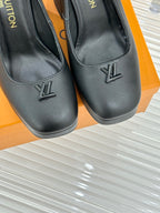 Close-up of black leather pumps with LV monogram on toe and curved topline