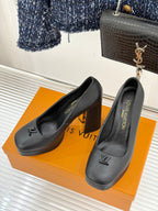 Pair of black leather Louis Vuitton-style pumps with LV logo on toe, high block heel