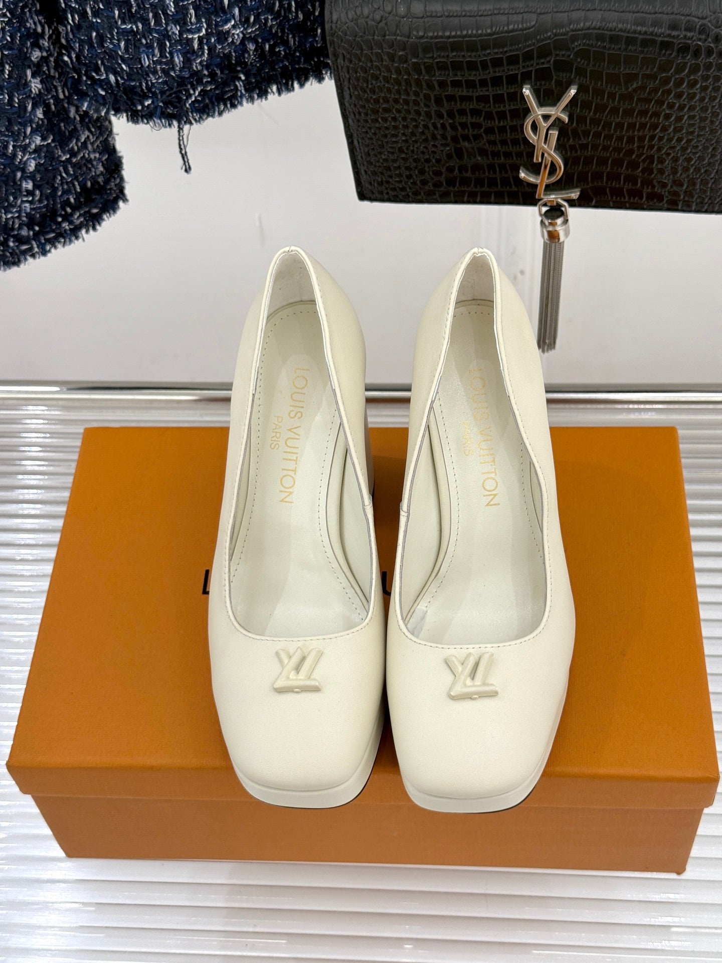 Louis Vuitton cream leather high-heel pumps with LV logo on front, two shoes shown