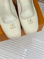 Louis Vuitton cream leather high-heel pumps close-up, LV logo on rounded toe