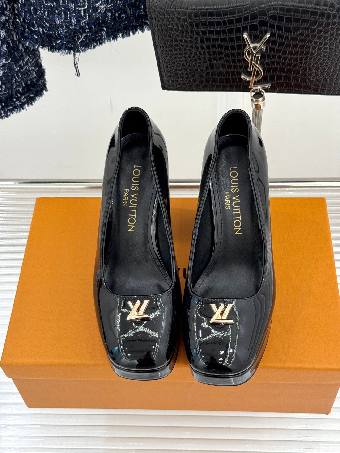 Louis Vuitton black patent high-heel pumps with gold LV logo, front view