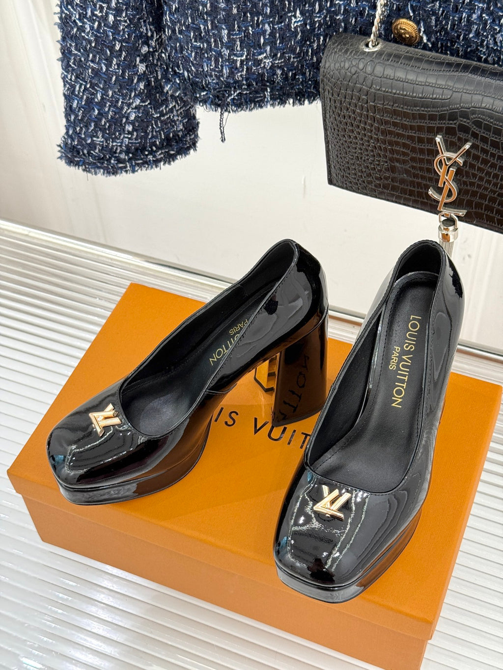 Louis Vuitton black patent high-heel pumps, glossy finish, gold LV emblem on front
