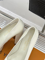 White leather pumps with pointed toe and gold logo accent, shown from side angle