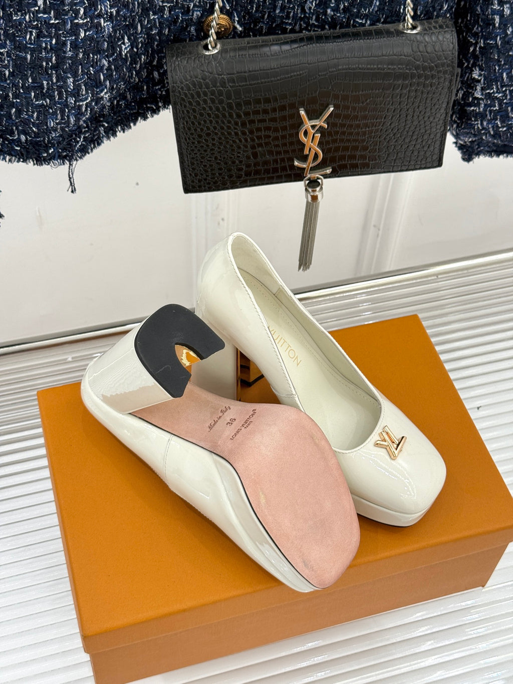 White leather pumps with pointed toe and gold logo emblem, with spare dust cover