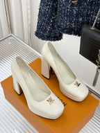 White leather high-heel pumps with pointed toe and gold logo emblem on the front