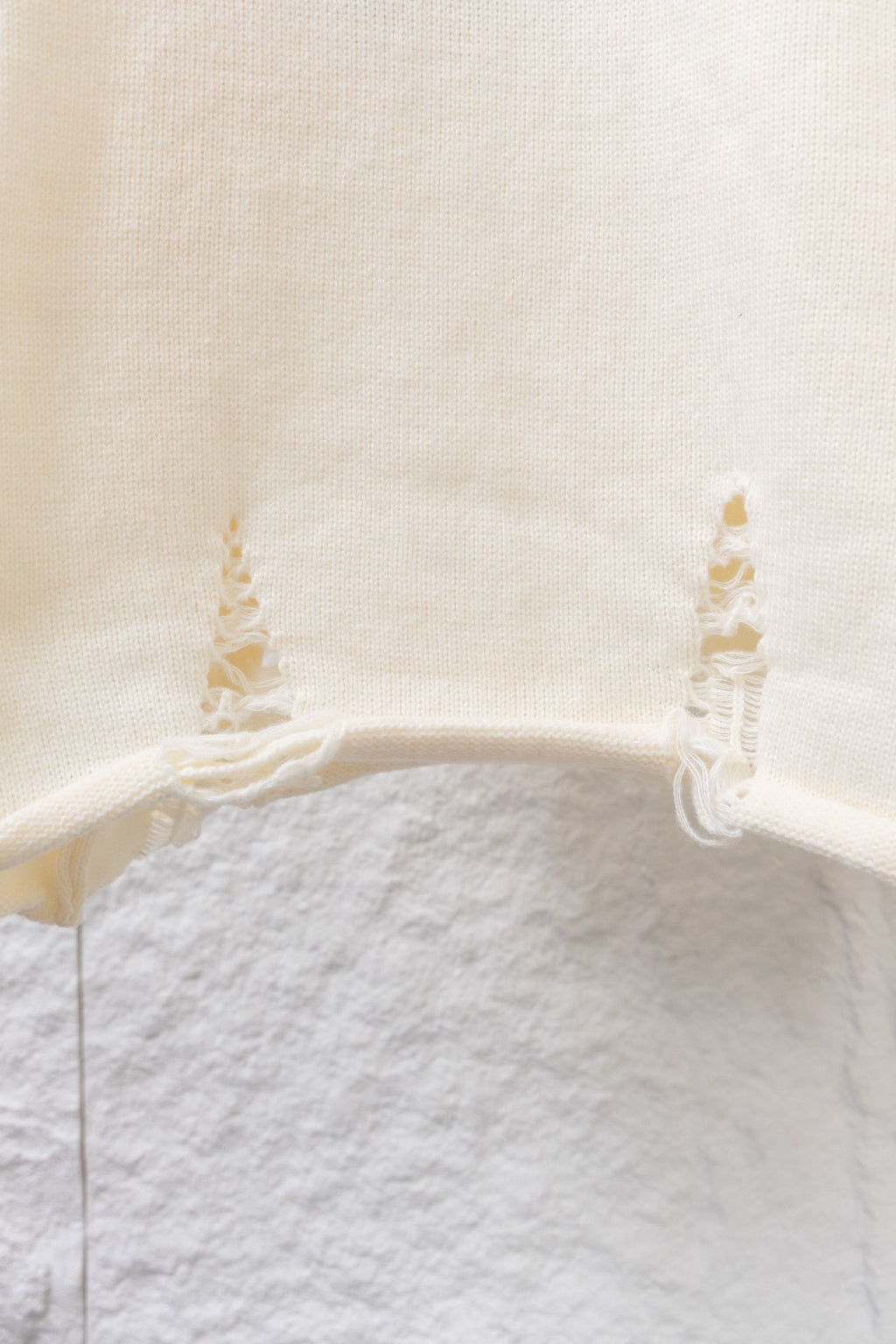Cream knit long sweater with ribbed hem and small lace ruffle at cuffs