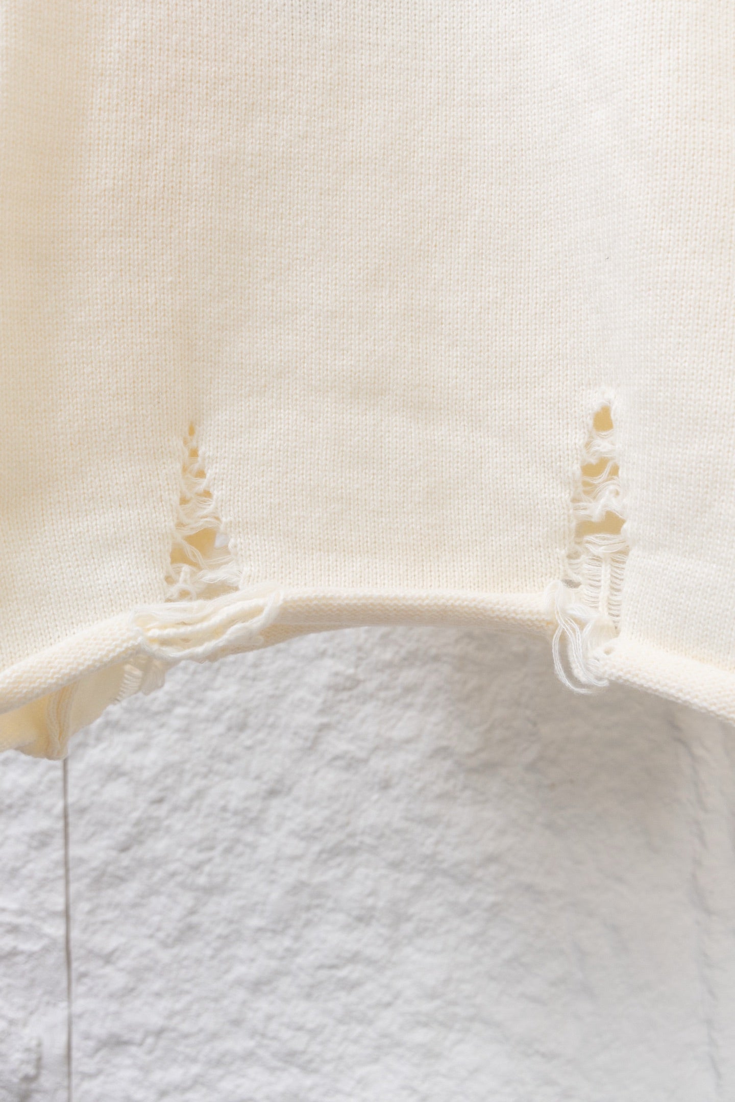 Cream knit long sweater with ribbed hem and small lace ruffle at cuffs