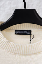 Cream knit sweater neckline with black brand tag on a hanger
