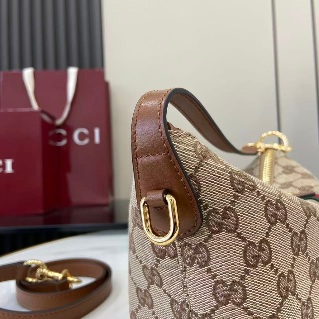 Gucci monogram shoulder bag side view with brown leather strap and gold hardware