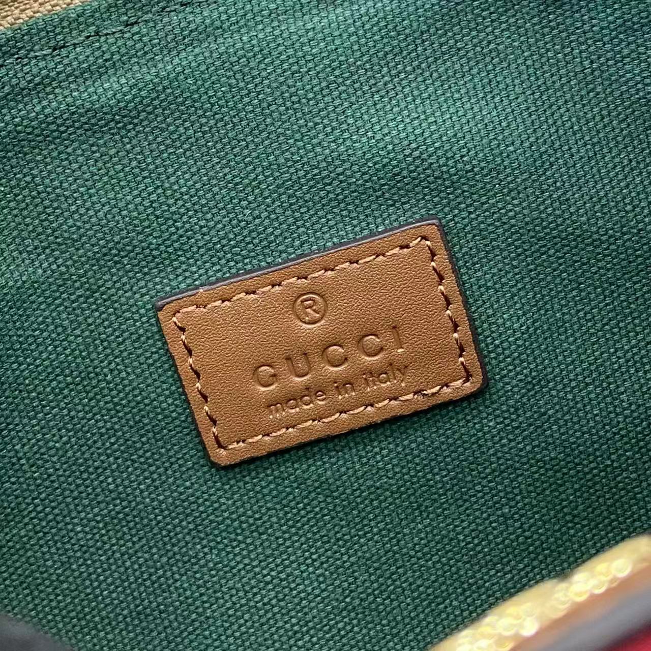 Gucci interior label on green fabric with brown leather tag and logo text