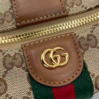 Gucci monogram bag close-up: brown leather patch with GG logo and web stripe