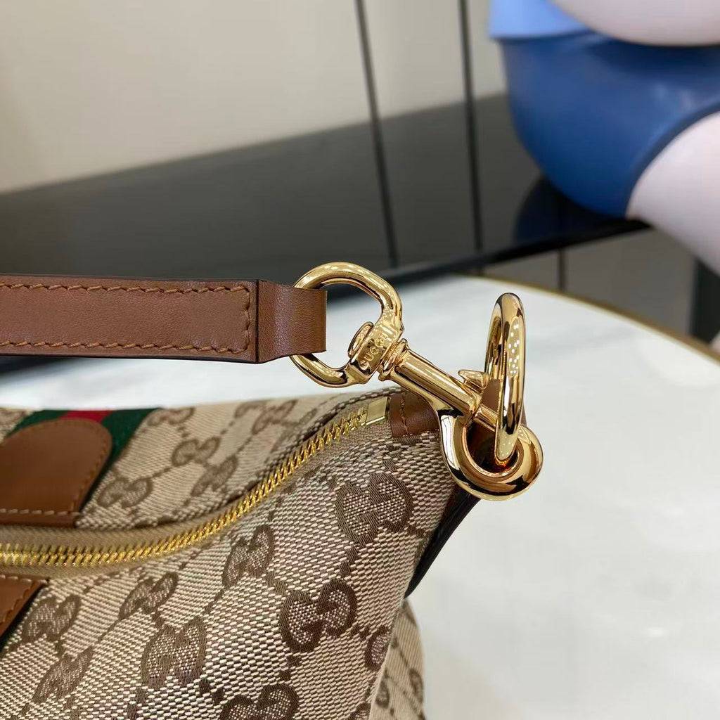 Gucci monogram bag hardware close-up with gold clasp and brown leather strap