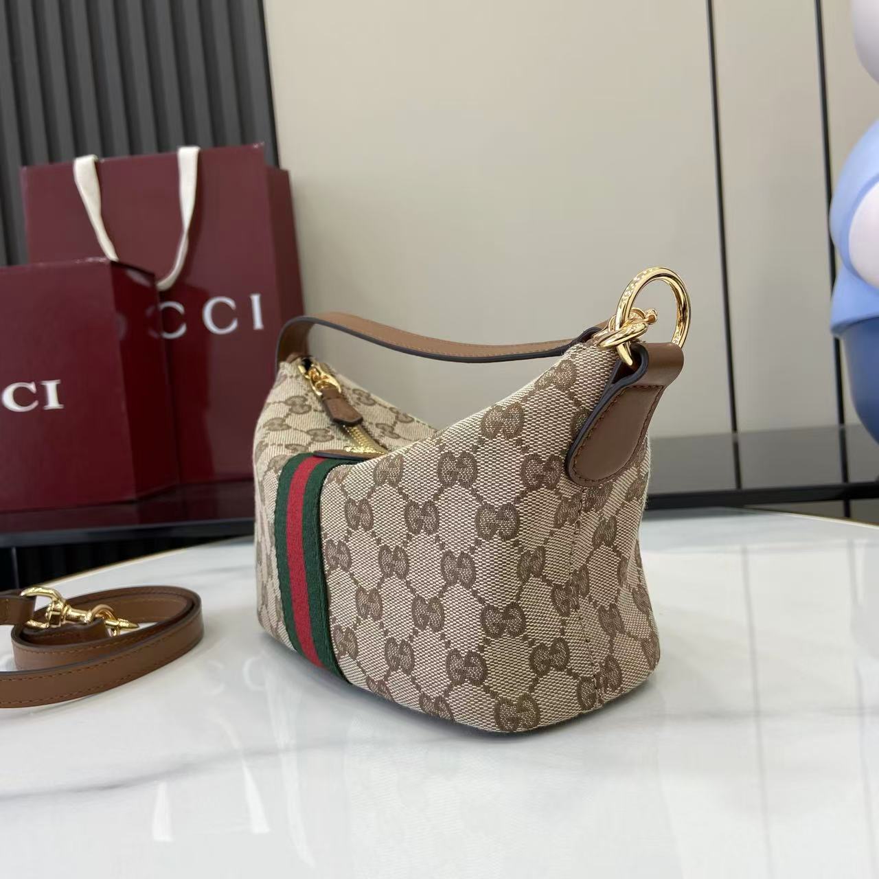 Gucci monogram hobo bag with beige canvas, web stripe, and top gold ring handle