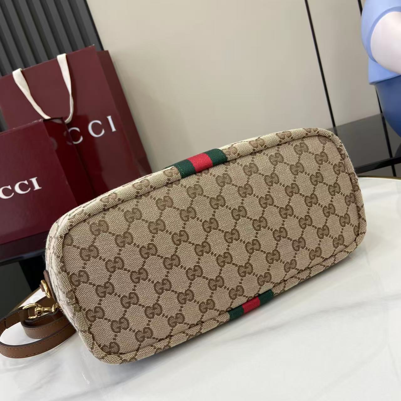 Gucci hobo bag angled view with GG canvas and green/red web stripe, gold hardware
