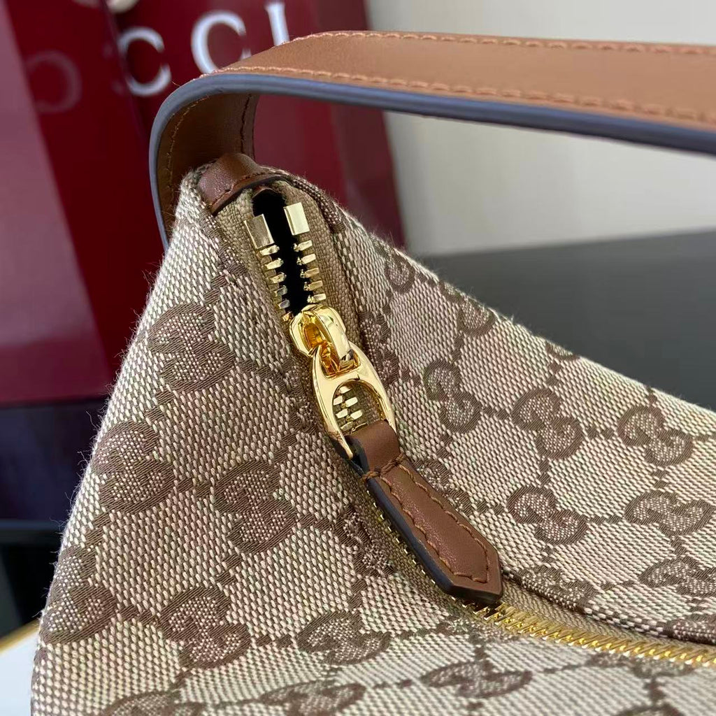 Gucci bag close-up of zipper with gold pull on GG canvas and leather trim
