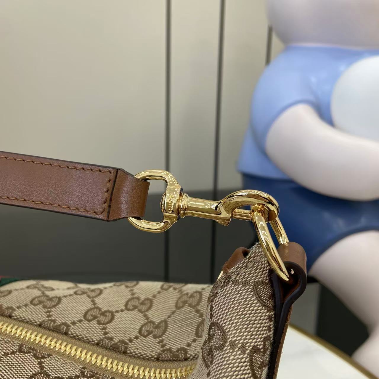 Gucci bag shoulder strap and gold-tone hardware with zipper pull, brown