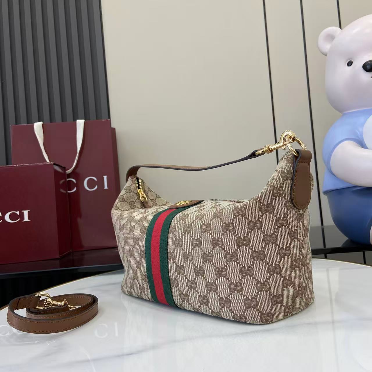 Gucci hobo bag front 3/4 view with GG canvas, green/red web stripe and top handle