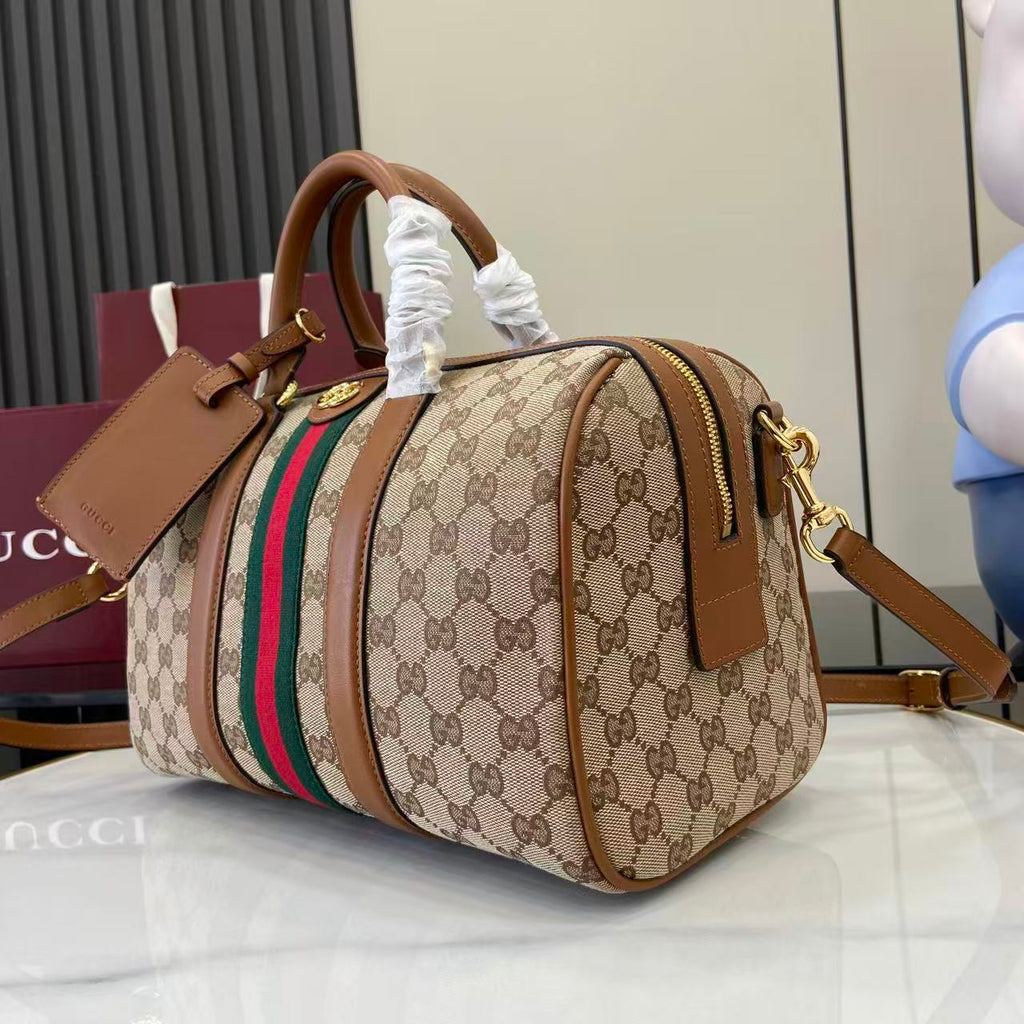 Gucci duffel bag angled view with GG canvas, multicolor web stripe, gold-tone zipper pull