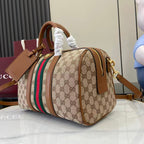 Gucci duffel bag angled view with GG canvas, multicolor web stripe, gold-tone zipper pull