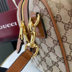 Gucci bag with GG monogram canvas, brown leather trim, and gold clasp hardware