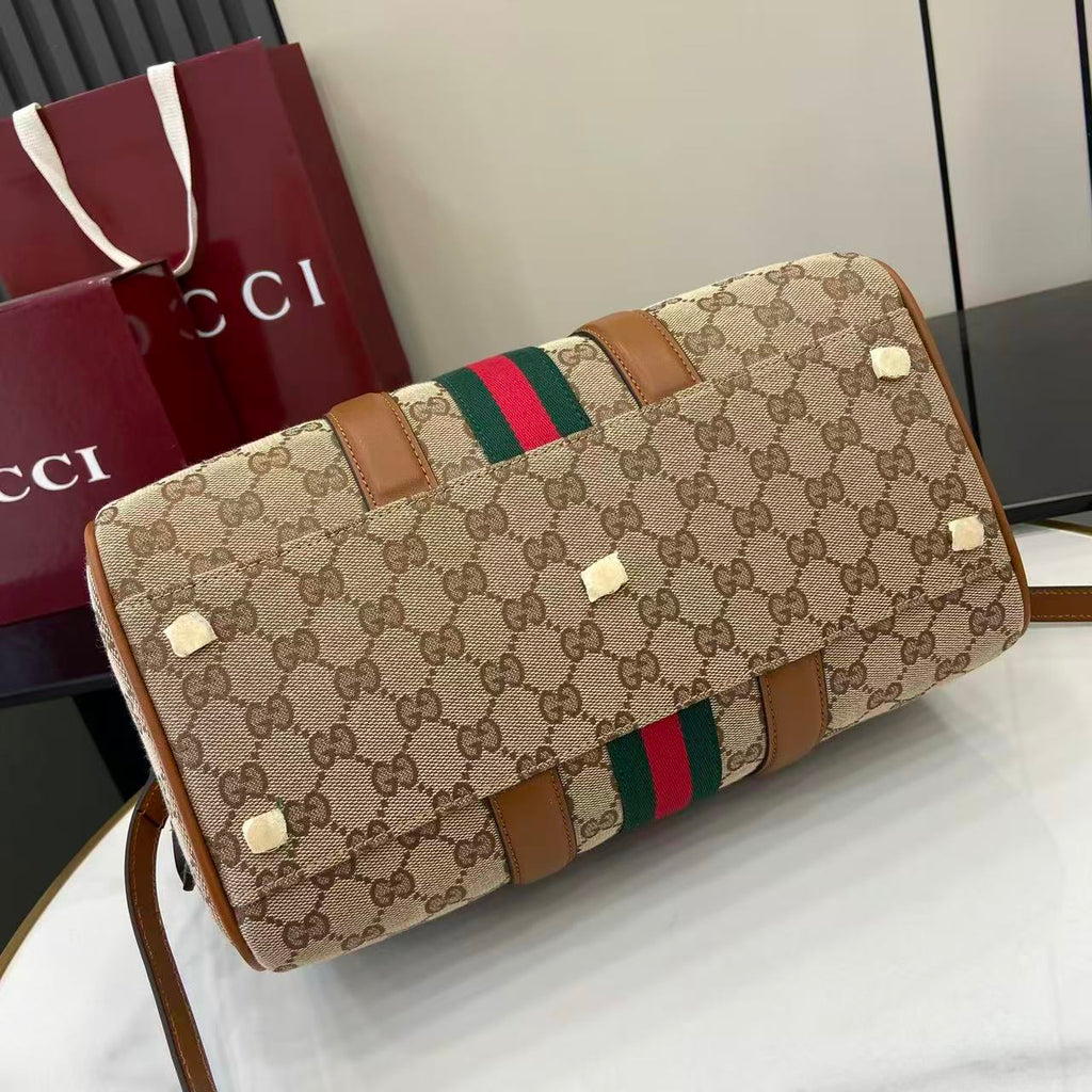 Gucci duffel bag end view with GG canvas, green and red web stripe, brown leather details