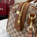 Gucci duffel bag close-up with GG canvas, brown leather trim, gold hardware and zipper