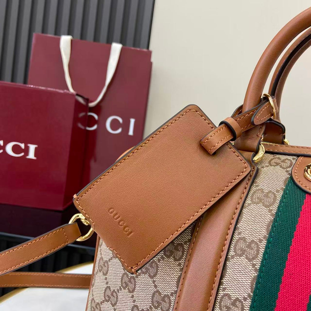Gucci bag close-up of front pocket with brown leather flap, GG canvas, and web stripe