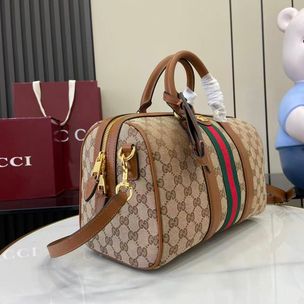 Gucci duffel bag side view with GG canvas print, green and red web stripe, leather straps