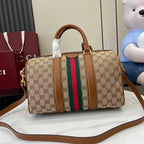 Gucci duffel bag front view in GG canvas with multicolor web stripe and brown crossbody strap
