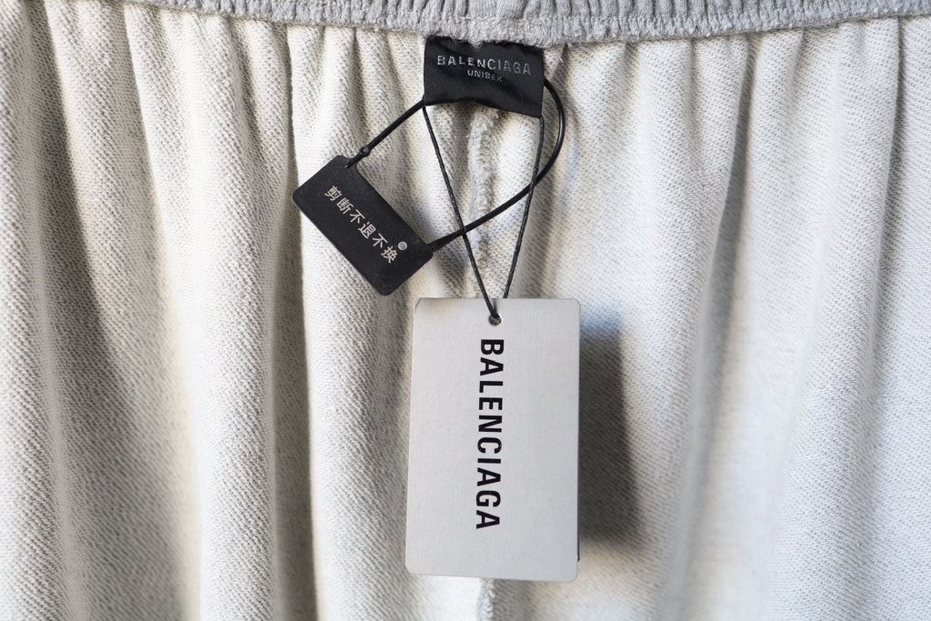 Light gray pants with hang tag reading Balenciaga