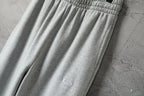 Light gray wide-leg pants with small logo detail on fabric
